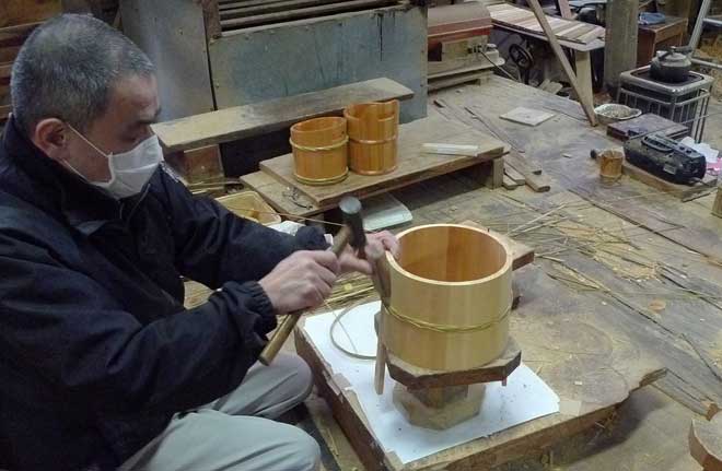 竹の箍を木桶を締め込むように取り付ける